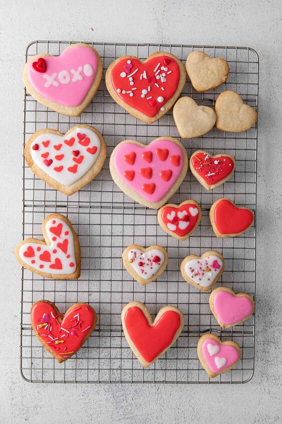 iced shortbread cookies, several red and pink iced shortbread cookies on a wire rack