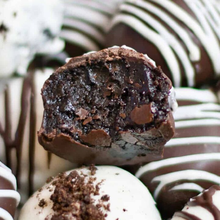 peanut butter cup stuffed truffles, Close up on an Oreo ball with a gooey bite missing on top of other Oreo balls