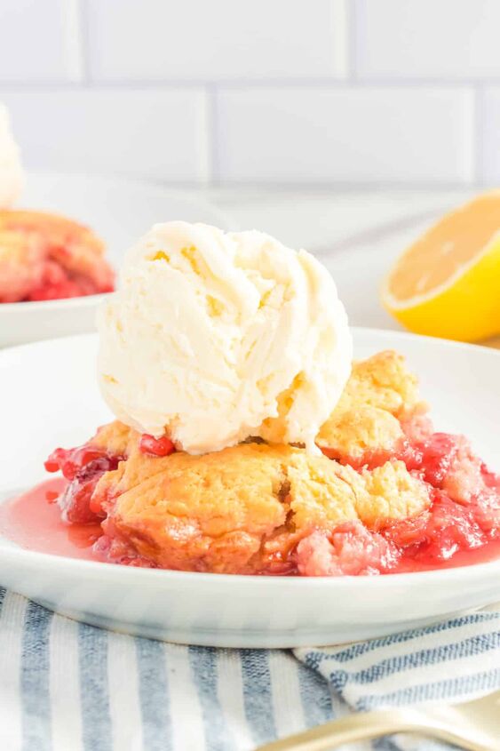 fresh strawberry cobbler, Strawberry cobbler scooped onto a plate with a big scoop of vanilla ice cream from the side