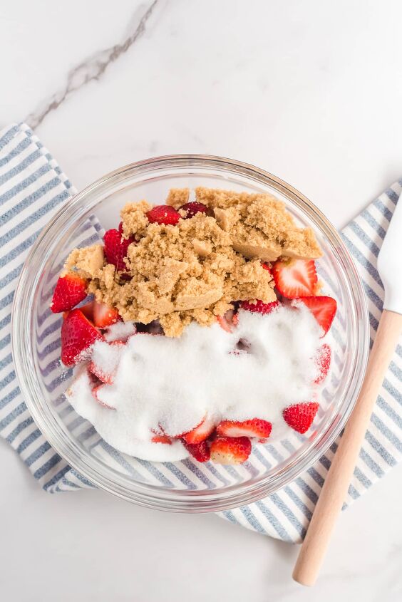 fresh strawberry cobbler, Sliced strawberries in a bowl from overhead covered in brown sugar and white sugar