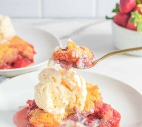 fresh strawberry cobbler, A fork full of strawberry cobbler and ice cream being scooped from a plate on a counter from the side