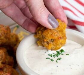 sausage and cheese balls, A hand dipping a sausage and cheese ball into a white dipping sauce