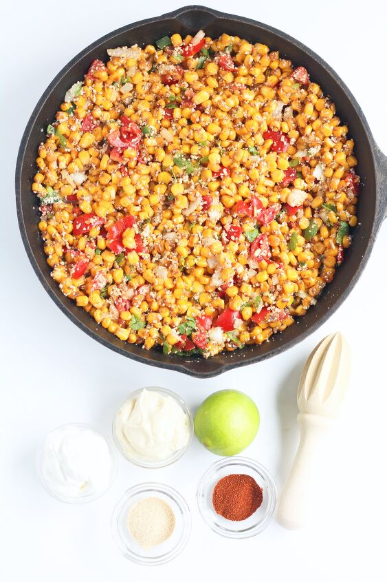 elote recipe off the cob elote corn dip, Corn with tomatoes and other vegetables in a skillet with ingredients for the sauce nearby on the table from overhead