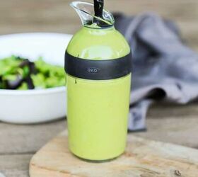 keto vegan avocado dressing recipe gluten free, bottle of vegan avocado dressing recipe in a salad dressing container on a cutting board with a knife