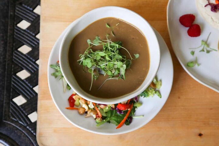 gluten free cream of mushroom soup vegan, bowl of vegan mushroom soup garnished with microgreens in a white bowl on a white plate with salad