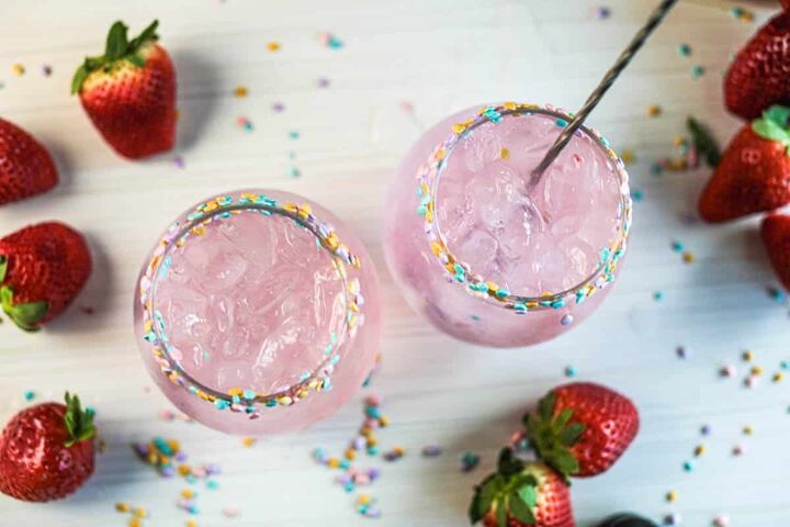 drunk bunny cocktail perfect for a grown up easter, Pink cocktails with sprinkles on rim and stir stick with strawberries and sprinkles on table