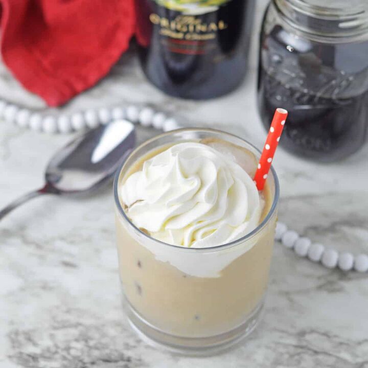 drunk bunny cocktail perfect for a grown up easter, Baileys Iced Coffee in a glass with whipped cream and a red straw
