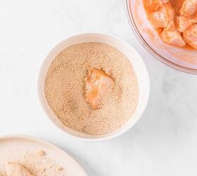Bowl of marinated chicken pieces smaller bowl with breadcrumbs and a piece of chicken coated in breadcrumbs a plate of breaded chicken pieces