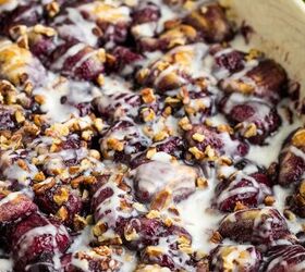 blueberry cobbler bubble up, A close up of a baked dish with a mixture of berries nuts and a white icing drizzle on top