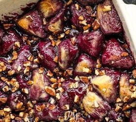 blueberry cobbler bubble up, A close up photo of a baked dish filled with caramelized figs and sprinkled with chopped nuts in a white rectangular baking dish