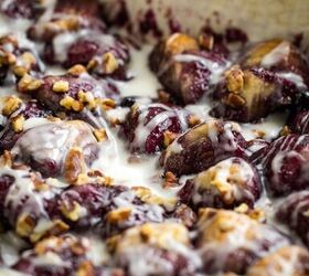 blueberry cobbler bubble up, A close up of a baked dish filled with Blueberry Cobbler Bubble Up covered in white icing and sprinkled with chopped pecans