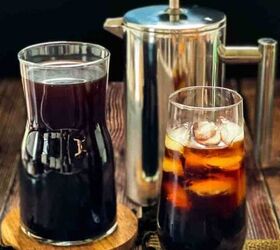 how to make the best iced coffee at home, Cold brew coffee in a tall glass with ice with a pitcher filled with cold brew and a French press coffee maker behind it
