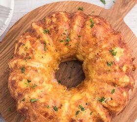 bundt pan hash brown breakfast casserole, up close view of breakfast casserole shaped by bundt pan and placed on serving board with parsley for garnish chopped parsley in small dish salt and pepper shakers on side