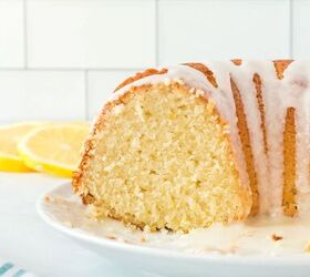 this lemon bundt cake recipe makes me happy, lemon bundt cake with white icing drizzled over it cut in half and shown on a white plate slices of fresh lemon in background