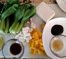 baby bok choy and tofu stir fry, ingredients on cutting board including 2 heads of baby bok choy tofu yellow pepper and onion