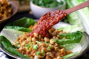 She puts some peanuts on lettuce and then dabs everything in a sauce she can't stop herself from devouring