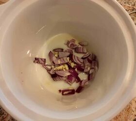 slow cooker vegan cholent, olive oil red onion and chopped garlic in slow cooker
