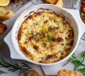 baked ricotta easy italian appetizer, A round white casserole dish filled with baked cheese dip surrounded by crostini and herbs