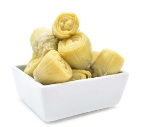 green chile artichoke dip with bacon, A dozen artichoke hearts in a white dish