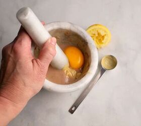 parmesan crusted chicken with caesar salad, Adding the mustard and egg yolk to the mortar and pestle