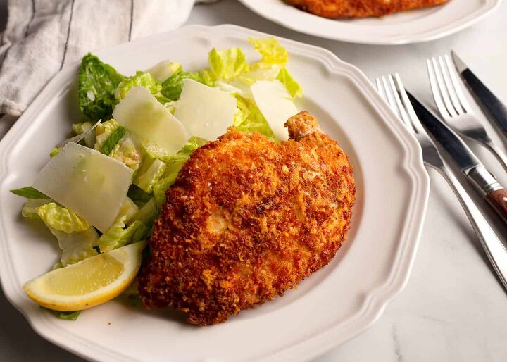 parmesan crusted chicken with caesar salad, Close up of the Parmesan Chicken with the salad and parmesan shavings