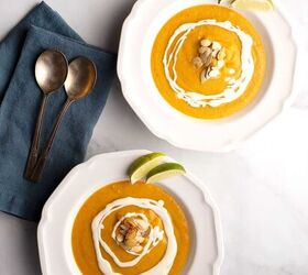southwest pumpkin soup, two servings of Southwest Pumpkin Soup with cream drizzled pumpkin seeds and lime wedges