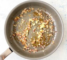 creamy bow tie pasta salad with crispy pancetta, A frying pan with saut ed garlic and shallots lightly browned on a light countertop