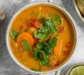 coconut curry soup, A white bowl of vibrant coconut curry soup garnished with cilantro