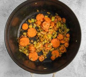 coconut curry soup, Large black cooking pot with saut ed carrots onions and celery