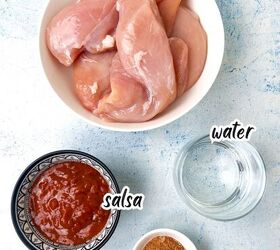 how to make shredded chicken in crockpot, Ingredients including raw chicken breasts in a bowl a glass of water a small bowl of salsa and a dish of taco seasoning all labeled on a light blue textured background