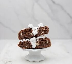 easy hot chocolate marshmallow fluff stuffed cookies, hot chocolate marshmallow cookie cut in half with marshmallow fluff oozing out