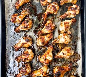 easy soy garlic chicken wings recipe, A baking tray filled with evenly spaced golden brown soy garlic chicken wings on parchment paper with visible caramelization and savory juices
