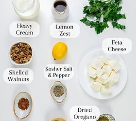 A flat lay of ingredients on a white surface olive oil fresh parsley heavy cream lemon zest feta cheese shelled walnuts kosher salt and pepper red pepper dried oregano and fresh garlic