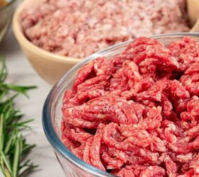 homemade meatloaf with creamy onion gravy, A glass bowl filled with raw ground beef is in the foreground with another bowl of minced meat eggs and fresh rosemary in the background