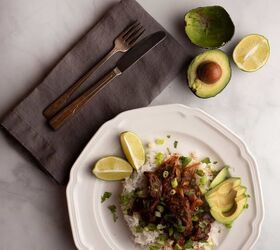 mexican beef stew, A serving of Mexican Beef Stew served on rice with avocado and limes