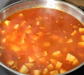 aloo matar recipe potato and peas no onion garlic, Potatoes cooking in spices and gravy in a stainless steel frying pan