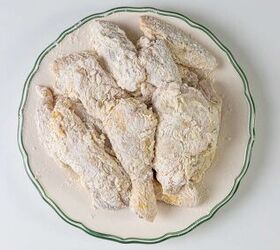 how to make buttermilk fried chicken, A plate of raw fish fillets coated in flour ready for cooking The fish is arranged neatly on a large round plate with a decorative green rim set against a white background