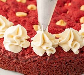 valentine s cookie cake red velvet cookie cake recipe, Piping the frosting on a valentines cookie cake