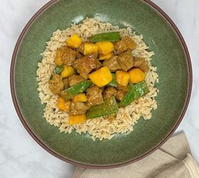 curried pork in coconut sauce with mango snow peas, Green bowl with Curried Pork in Coconut Sauce with Mango Snow Peas on a bed of brown rice