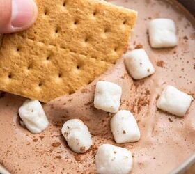 easy 3 ingredient hot cocoa dip, A hand dipping a graham cracker into hot cocoa dip