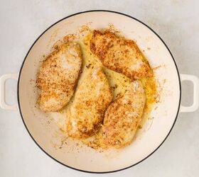 parmesan lemon chicken, chicken seared and golden brown in a white skillet