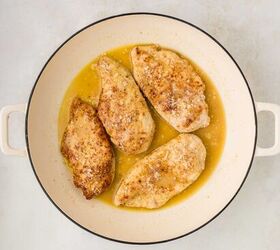 parmesan lemon chicken, cooked chicken with the sauce in a white skillet