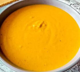 curried lentil carrot soup, Gorgeous yellow colored soup is served in a round grey colored bowl