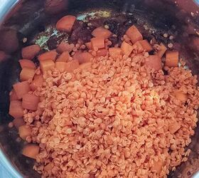 curried lentil carrot soup, Some red lentils and carrots are placed on top of some spices in a soup pot