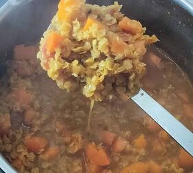 curried lentil carrot soup, Some cooked lentils and carrots for making soup are being held in a ladle while others are cooking in a saucepan below