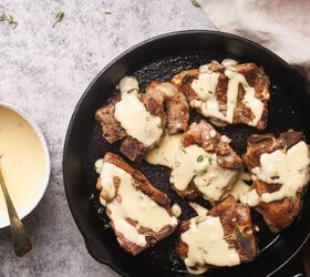 pan seared lamb loin chops with garlic sauce, Lamb loin chops in a cast iron skillet next to a saucepan with a creamy sauce