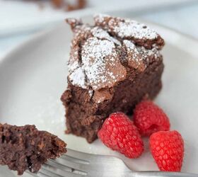 flourless chocolate cake passover, A slice of flourless chocolate cake on a white plate with a fork holding one piece