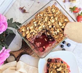 chia berry oat crumble, Close up view of the berry crumble in a glass rectangular dish with a portion taken out and plated beside it There are a few fresh berries by the side
