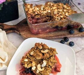 chia berry oat crumble, An image showing a freshly baked berry crumble in a glass dish with a portion served on a plate in the foreground