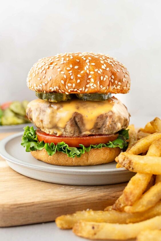 instant pot turkey burgers, turkey burger on a bun with lettuce tomato cheese and fries on the side